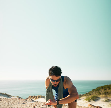 Fitness, break and man with smart watch by beach, mockup space and check heart rate for training. Running pause, track distance and athlete with tech to count steps, sunglasses and monitor rest timeの写真素材