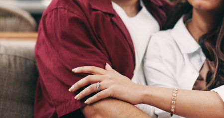 Engagement ring, hands or couple with hug on couch, commitment or loyalty promise in marriage jewellery. Romantic connection, relationship or people embrace in home together, love or anniversary giftの写真素材
