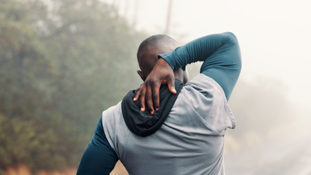Back, fitness and stretching with man on mountain trail for start of cardio or training routine. Exercise, warm up and workout with athlete person outdoor in overcast forest for health or wellnessの写真素材