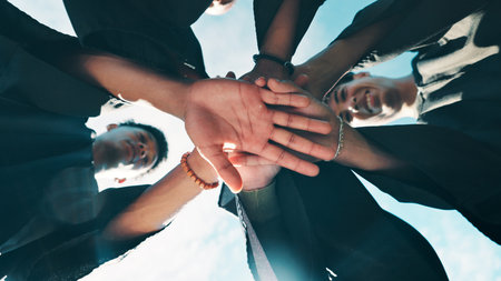 Graduation, outdoor or people with hand stack on campus, solidarity or support for education milestone. Achievement, goal or college students together for learning success, friends celebrate or belowの写真素材
