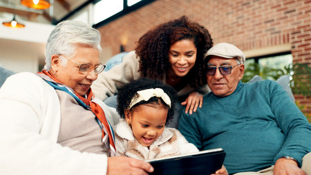 Grandparents, girl and mother on sofa with tablet, relax and bonding with movie in living room. Senior people, child and mom with application, streaming or film subscription on couch at family houseの写真素材