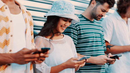Phone, smile and typing with friends outdoor together for connection or social media browsing. App, contact and text message with group of happy people in line for chatting online or communicationの写真素材