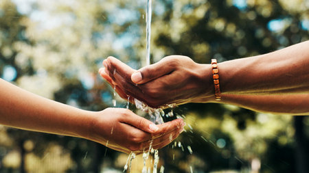 Water, hands and splash in nature for sustainability, wash or share liquid together. People, fingers and cleaning with drops outdoor for hygiene, environment wellness or community support for ecologyの写真素材