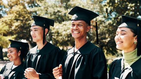 Happy people, student and graduation with qualification on campus for education or learning. Group, graduate and smile with degree or diploma for academic milestone or achievement in outdoor ceremonyの写真素材