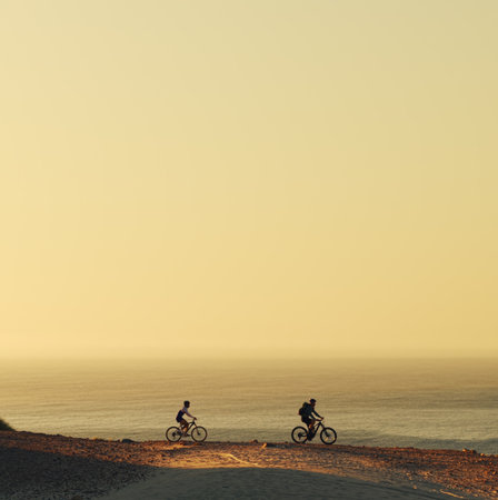 People, cycling and mountain bike with beach view for outdoor journey or adventure in nature. Cyclist, friends or fitness with bicycle by ocean for extreme sport, exercise or travelの写真素材