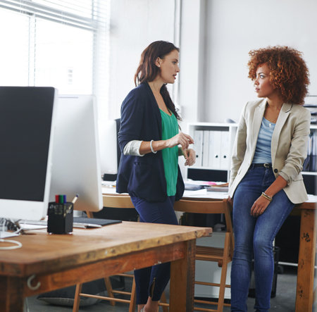 Team, talking and business women in office for budget planning, finance review and proposal. Professional, accounting and people in discussion for financial report, company revenue and feedbackの写真素材