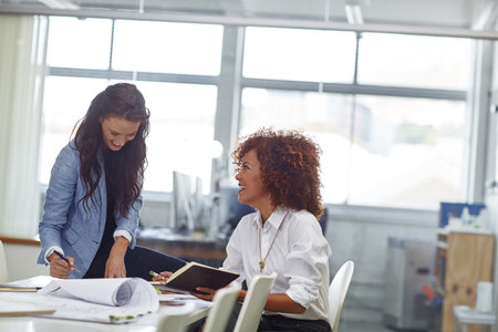 Women, team and discussion in meeting with diary for architecture, building project and collaboration. Happy, people and architect in workplace with communication, design planning and partnership.の写真素材