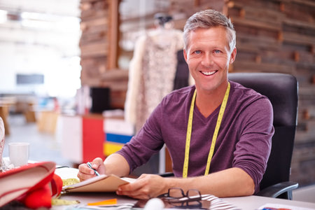 Fashion designer, mature man and notebook in workshop for sketching, design process and planning....