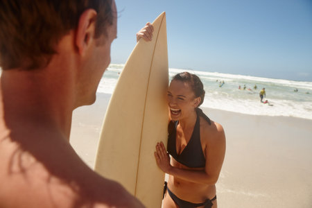 Surfboard, laughing and couple on beach for fitness, vacation or weekend trip in summer. Happy,...