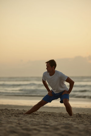 Exercise, space and stretching with man on beach for start of training or workout routine. Fitness,...