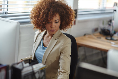 Computer, thinking and business woman in company for policy development, problem solving or idea. Desktop, planning and serious consultant in office for compliance review, reflection or insightの写真素材