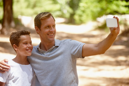 Happy dad, son or forest with selfie for picture, photography or outdoor memory together. Father,...