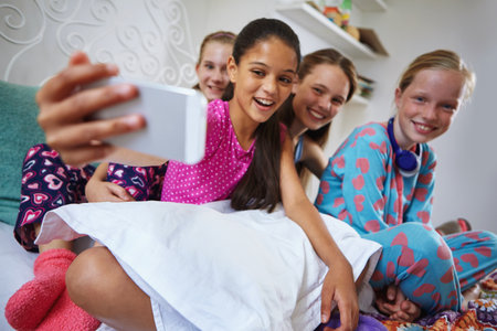 Selfie, smile and teenagers at sleepover in home for memory, fun and social media post together. Bonding, happy and group of girl friends with photography picture for hangout in bedroom on weekend.の写真素材