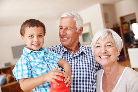 Happy, portrait and grandparents with child in home on weekend for bonding, love and family. Smile,...
