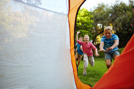 Kids outdoor, game and chasing in tent for camping activity, childhood memories and bonding...