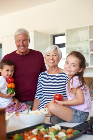 Food, portrait and grandparents with children in kitchen for learning, thanksgiving holiday reunion and meal prep. Festive season, support and lunch with family in home for teaching and cookingの写真素材