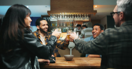 Friends, toast beer and excited at bar, celebration and bonding for party, happy hour and drinks. People, glasses and cheers at pub with alcohol, success or social gathering with reunion at nightの写真素材