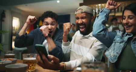 Cellphone, cheering and men in pub for sports game with goal, victory or winning championship. Happy, phone and group of male friends with celebration for watching football match in bar together.の写真素材