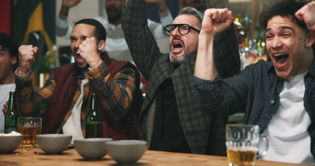 Happy people, winning and celebration with fist pump for sport victory, support or success in pub. Excited group, men or fans with achievement for goal, online entertainment or score in local barの写真素材