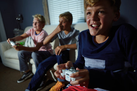 Children, controller and video game with boy on sofa in living room of home together for fun. Console gaming, friends and entertainment with group of happy kids in apartment for online level upの写真素材