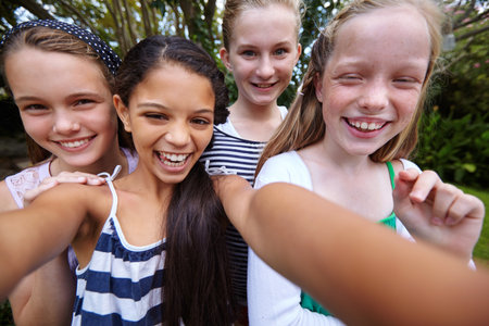 Happy girl, portrait and kids with selfie in nature for bonding, outdoor fun or weekend together. Teenagers, smile or group of friends with picture for photography, capture moment or social mediaの写真素材