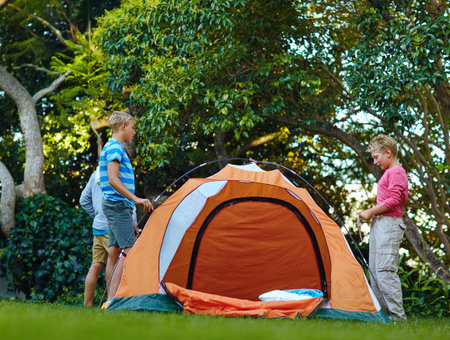Boys, friends and building tent for backyard camping, construction and help with learning, game and fantasy. Children, group and outdoor for shelter, support or talk on summer vacation with adventureの写真素材