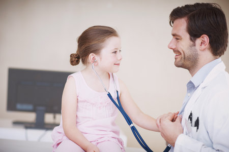 Doctor, stethoscope or child in hospital with play, pretend or comic relief in medical checkup. Happiness, healthcare or pediatrician in clinic with tool, imagination or breath game in consultation.の写真素材