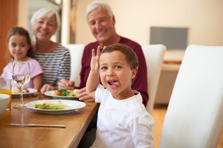 Happy, food and child with family in dining room of home for eating, thanksgiving season and...