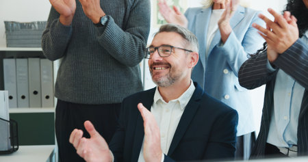 Businessman, team and applause at office meeting, success and achievement at investment agency. Mature person, group and clapping hands with goals, support or congratulations for milestone at companyの写真素材