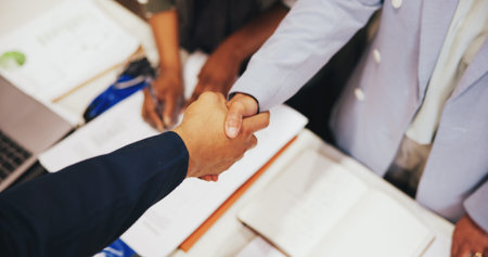 Above, handshake and people with agreement, meeting and documents with distribution deal. Closeup,...