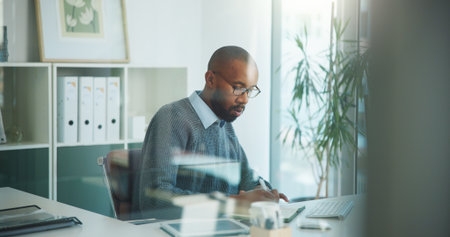 Writing, paperwork and business black man in office with finance report, proposal and budget review. Accountant, corporate and person with documents for financial planning, asset management and auditの写真素材