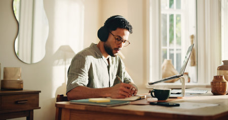 Headphones, remote work and writing with man in home office for journalism or publication. Music,...