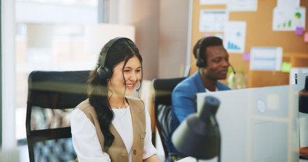 Happy woman, consultant or agency with headset in office for online advice or virtual assistance. Female person, employee or friendly agent with mic on computer for CRM communication, help or supportの写真素材