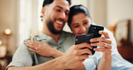 Happy couple, payment with phone in home for online shopping sale, purchase or embrace. Fintech, married people and hug in apartment with tech, ecommerce discount and eft transaction.の写真素材