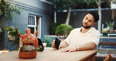 Phone, waiting and frustrated with man in home for late schedule, online dating fail and mistake. Cancel appointment, ghosting text message and time management crisis with person on patio of houseの写真素材