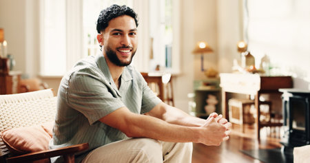 Property, portrait and man in home with smile, fresh start and investment in dream house. Real estate, happy and male person in living room with pride, relocation and achievement for new homeowner.の写真素材