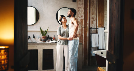Couple, hug and self care in bathroom for night, grooming routine and caring relationship in home. Connection, love and people for support in apartment with evening, hygiene or getting ready for bedの写真素材