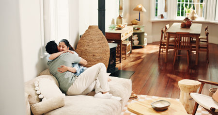 Relax, hug and love with couple on sofa of home for connection, romance and bonding. Support, happy and trust with man and woman embrace in living room of apartment for commitment, marriage and careの写真素材
