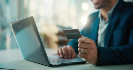 Credit card, hands and laptop with business man at desk in office for portfolio investment. Computer, payment and stock market trading with broker in financial workplace for purchase or transactionの写真素材