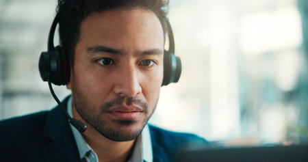 Agent, headset and man in call center with computer, loan recovery or debt collection. Communication, consultant or serious person with tech in office for banking inquiry, finance or payment reminderの写真素材