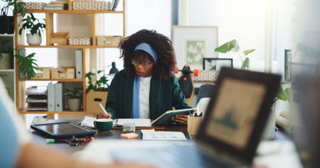 Woman, writing or notebook in office with tablet, financial analysis or eco friendly project in business. Person, coworking and notes with tech for finance results, stats info or sustainable company.の写真素材