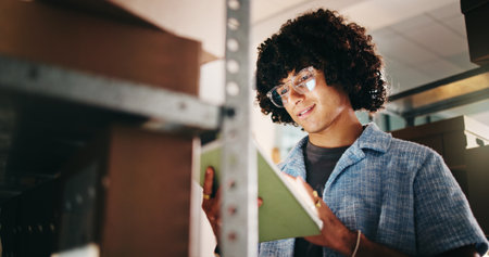 Smile, man and tablet with boxes in warehouse for inspection, information and inventory management. Male person, digital and low angle for stock check, supply chain and update price for distributionの写真素材