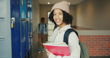 Smile, education and portrait of girl at lockers for future, child development and knowledge. Studying, growth and academy with student in school campus for learning, course curriculum and booksの写真素材