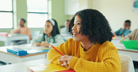Smile, education and listening with girl in classroom for lesson, child development and knowledge. Studying, happy and academy with student on school campus for learning, course curriculum and growthの写真素材
