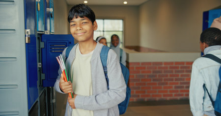 Smile, education and portrait of boy at lockers for future, child development and knowledge. Studying, growth and academy with student in school campus for learning, course curriculum and booksの写真素材