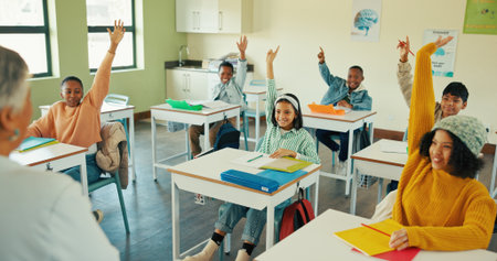 Knowledge, students and woman in classroom, questions and conversation with child development. Discussion, educator or people with hands raised, learning or teaching with assessment, studying or helpの写真素材