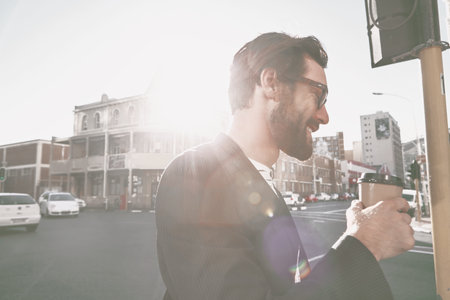 Coffee, happy and businessman in city in morning for commuting to work with creative career. Flare, professional and magazine editor walking with takeaway warm beverage outdoor in town for travel.の写真素材