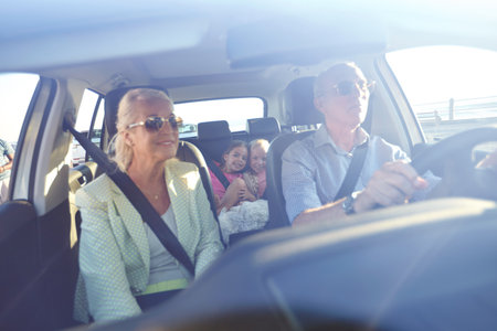 Adventure, road trip and senior people with grandkids in care for bonding, break or journey. Holiday, travel or vacation with girl children and grandparents in vehicle together for family outingの写真素材