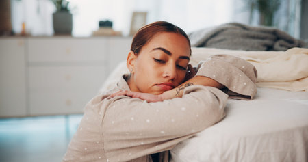 Woman, stress and depression by bed, thinking or reflection with mental health, frustrated or worry...