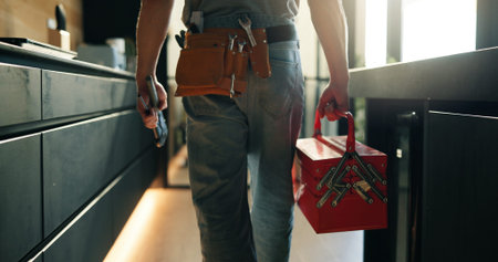 Walking, tool box and back of man in home for maintenance, service or repair job in kitchen....